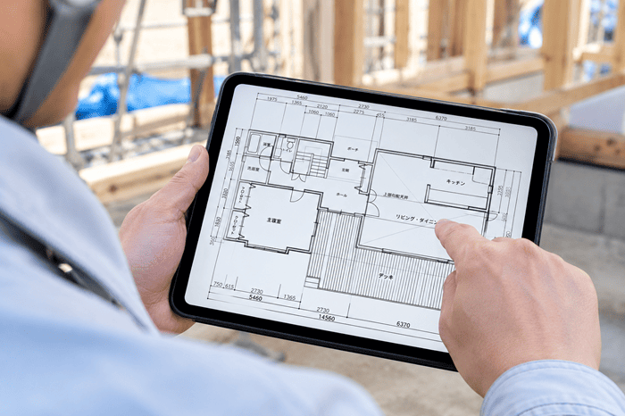 現場でタブレットの図面を確認しているイメージ